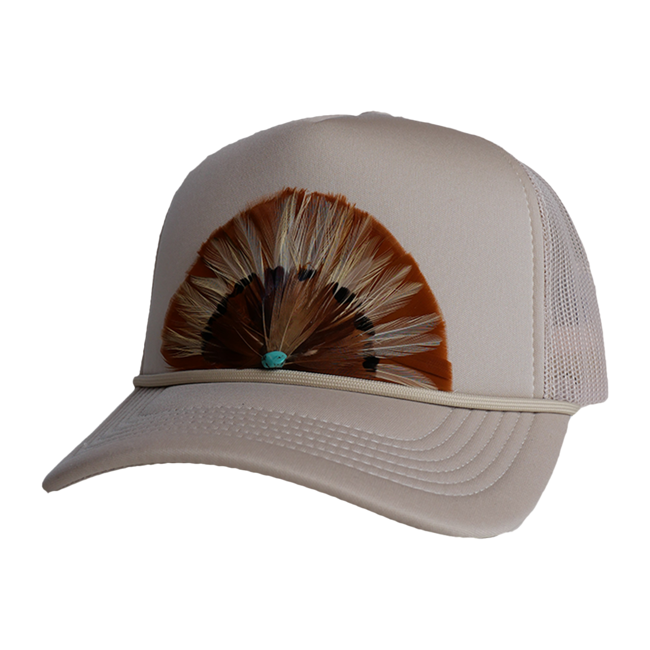 A black trucker hat with a hand-crafted feather detail on the front, displayed on a table with other hats in the background.