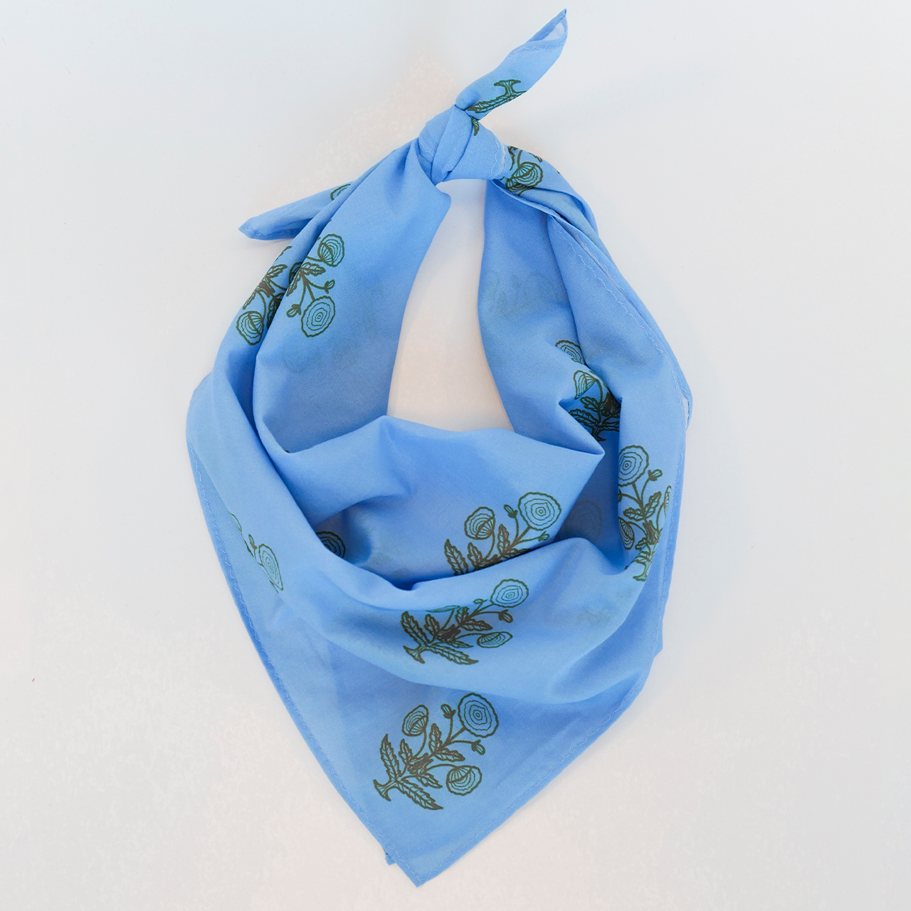 Blue bandana with green floral patterns on a white background