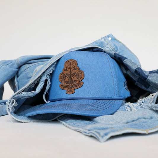 Blue cap with a brown logo on a denim fabric background
