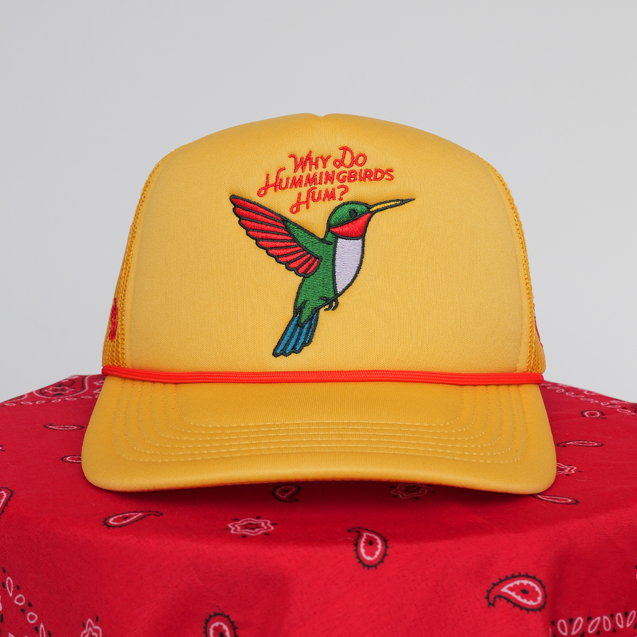 Yellow cap with a hummingbird design and text on a red bandana