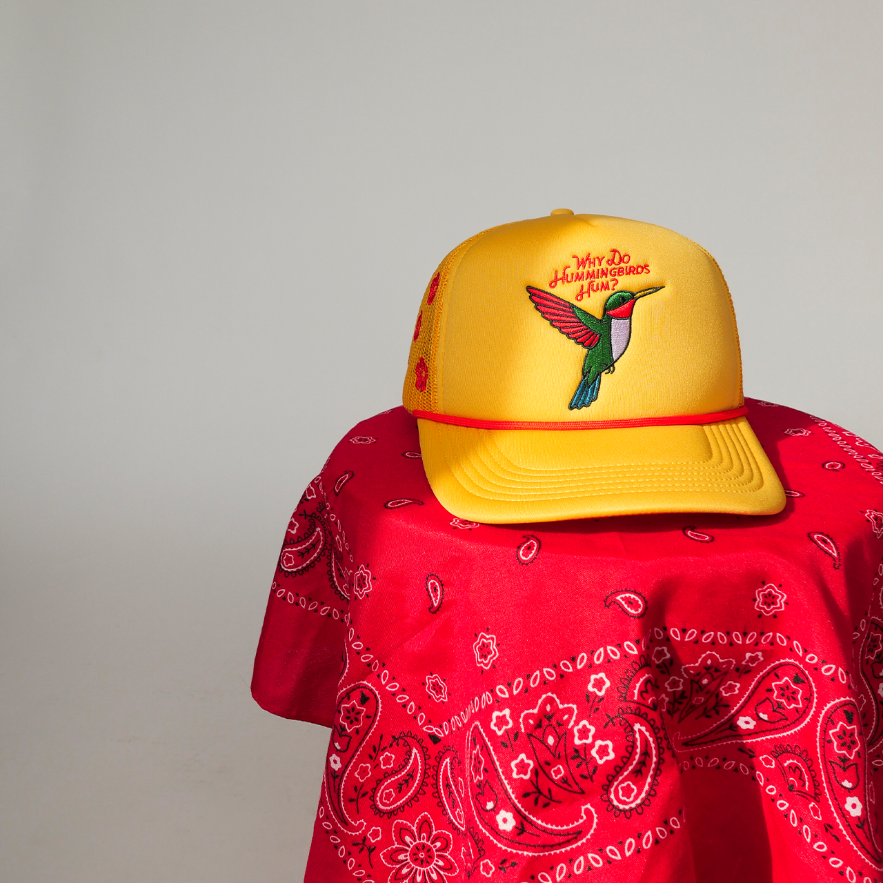 Yellow cap with a hummingbird design on a red bandana