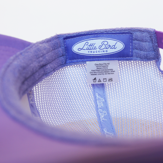 Purple cap with 'Little Bird Trucking' logo on a white background