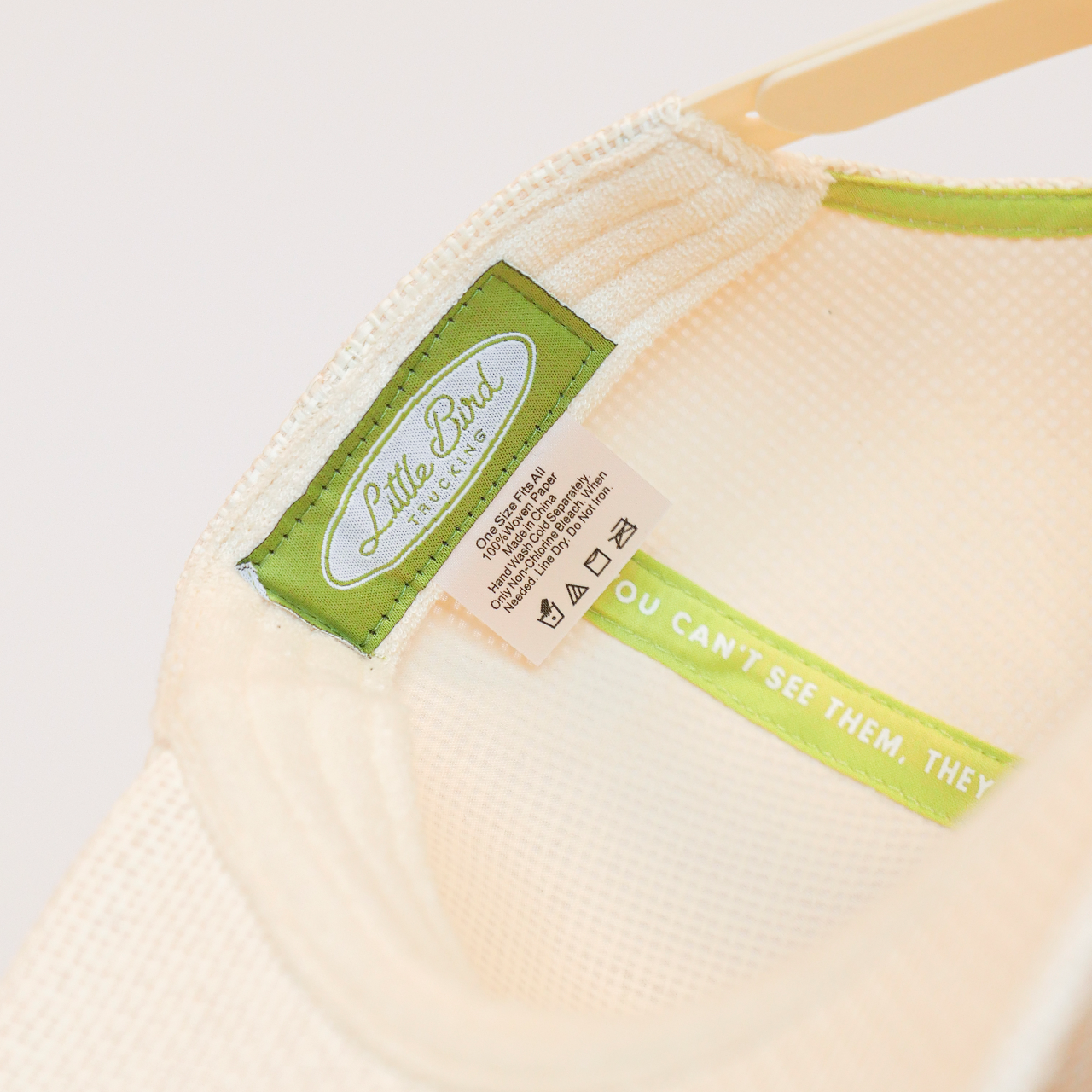 Close-up of a beige fabric product with a green label on a light gray background